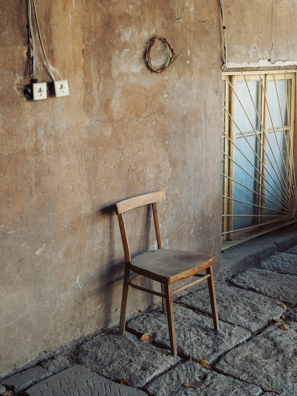 a wooden chair sitting in front of a wall