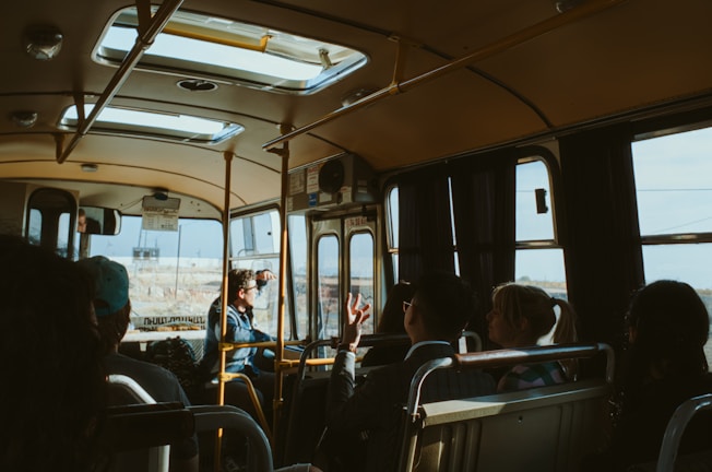 Group of happy students sitting inside a school bus during their ride