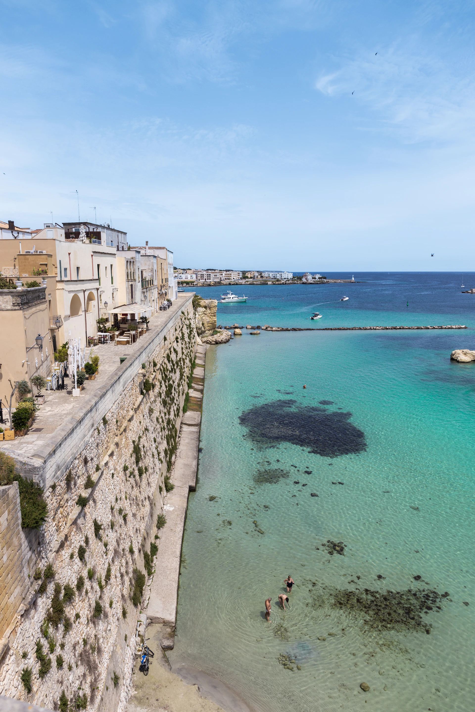 people are swimming in the clear blue water