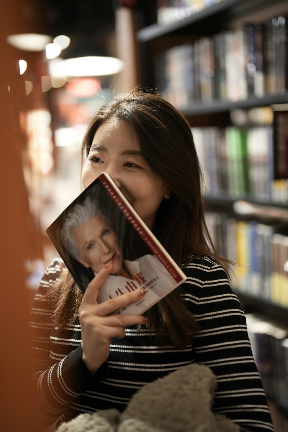 a woman holding a book in front of her face