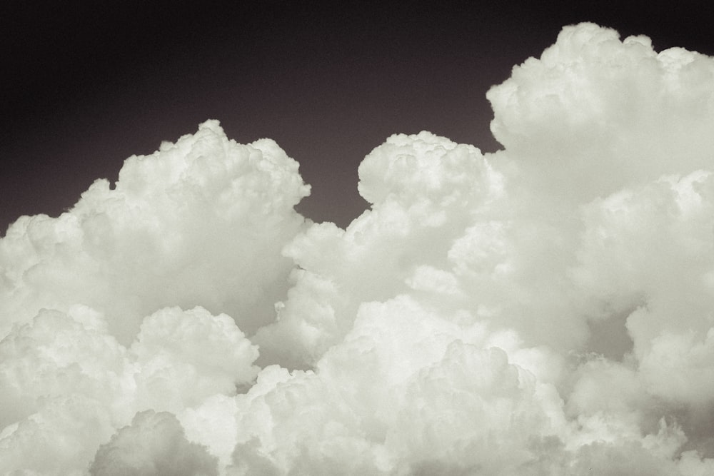 a plane flying through a cloud filled sky