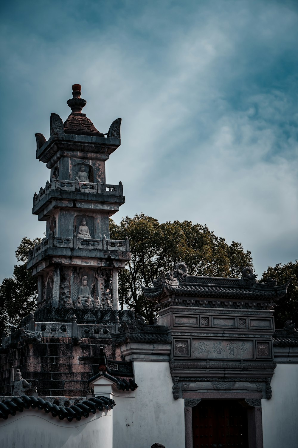 a tall tower with statues on top of it