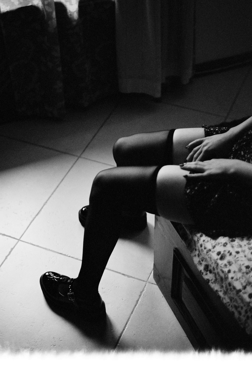 une femme assise sur un lit, les jambes croisées