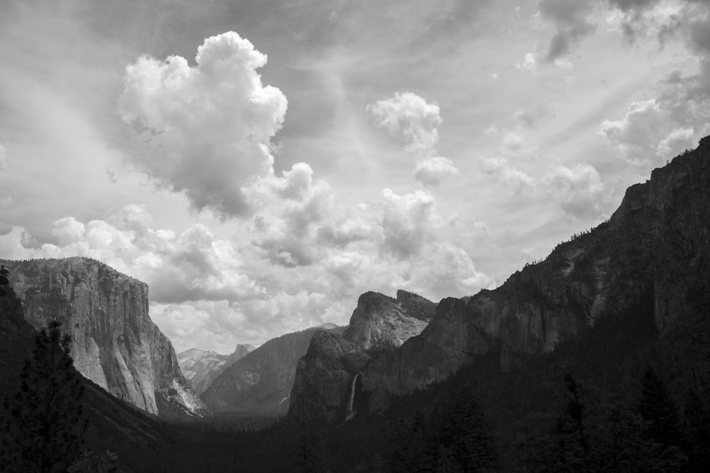 a black and white photo of mountains and clouds