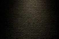 Close-up of an ancient clay tablet inscribed with cuneiform script, illuminated by warm orange light.