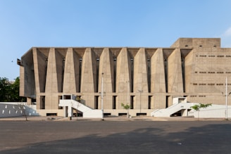 Wide shot of a public building with bold concrete pillars and open spaces.