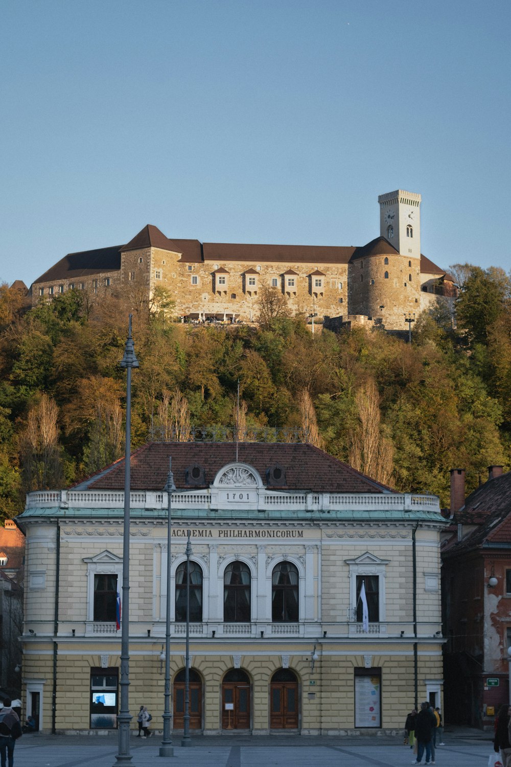 ein großes Gebäude mit einem Hügel im Hintergrund