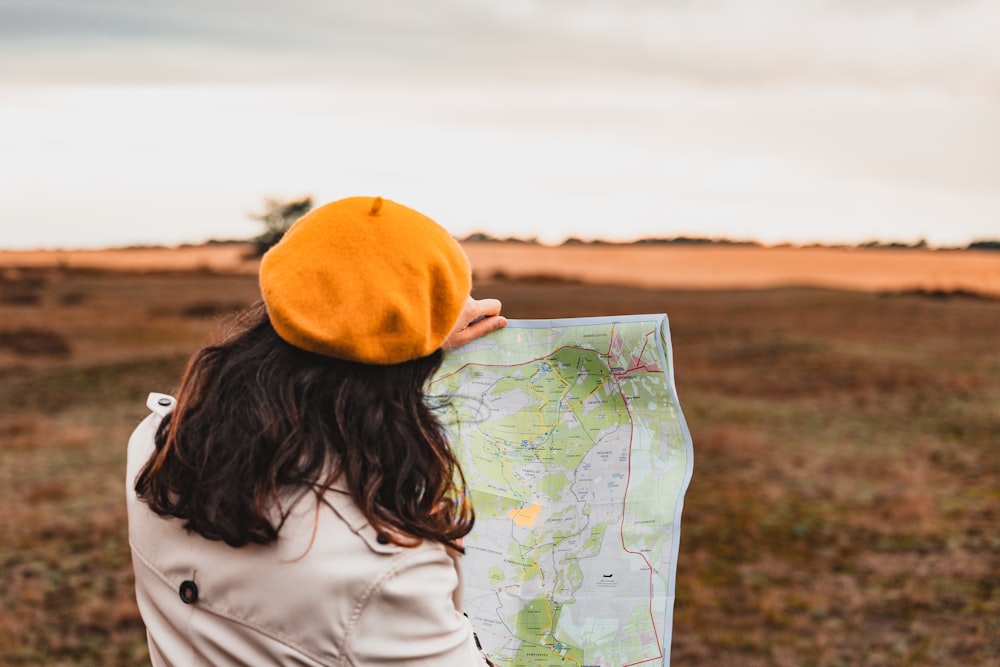 a woman holding a map in a field