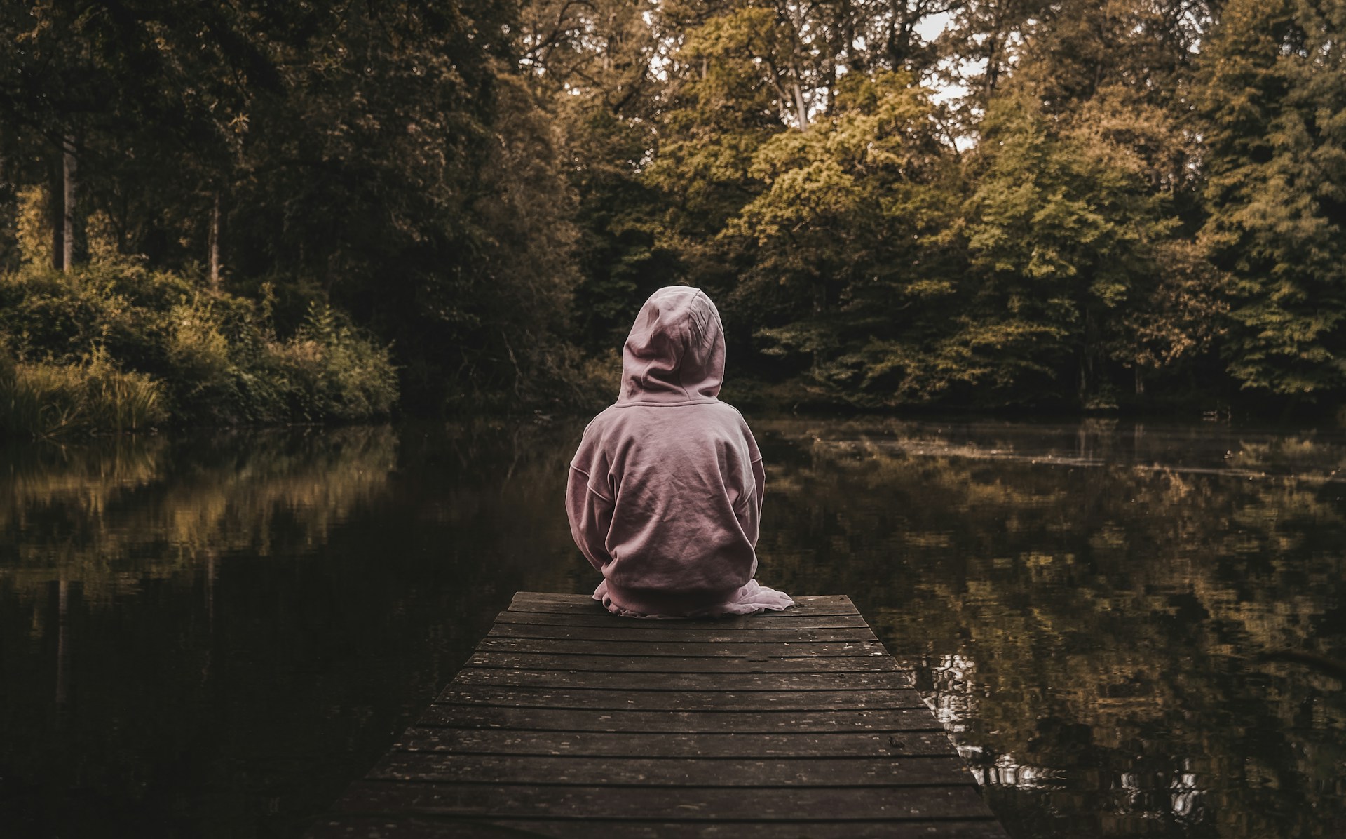 a person sitting on a dock looking at the water