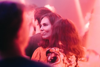 A warm, candid photo of the Pinkply team gathered in a bright, cozy workspace, smiling and engaged in conversation.