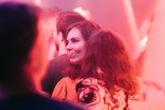 A warm, candid photo of the Pinkply team gathered in a bright, cozy workspace, smiling and engaged in conversation.