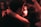A couple embraces closely in a dimly lit setting, sharing an intimate and joyful moment. The focus is on their faces, illuminated by warm, soft lighting, suggesting an atmosphere of affection and connection.