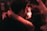 A couple embraces closely in a dimly lit setting, sharing an intimate and joyful moment. The focus is on their faces, illuminated by warm, soft lighting, suggesting an atmosphere of affection and connection.