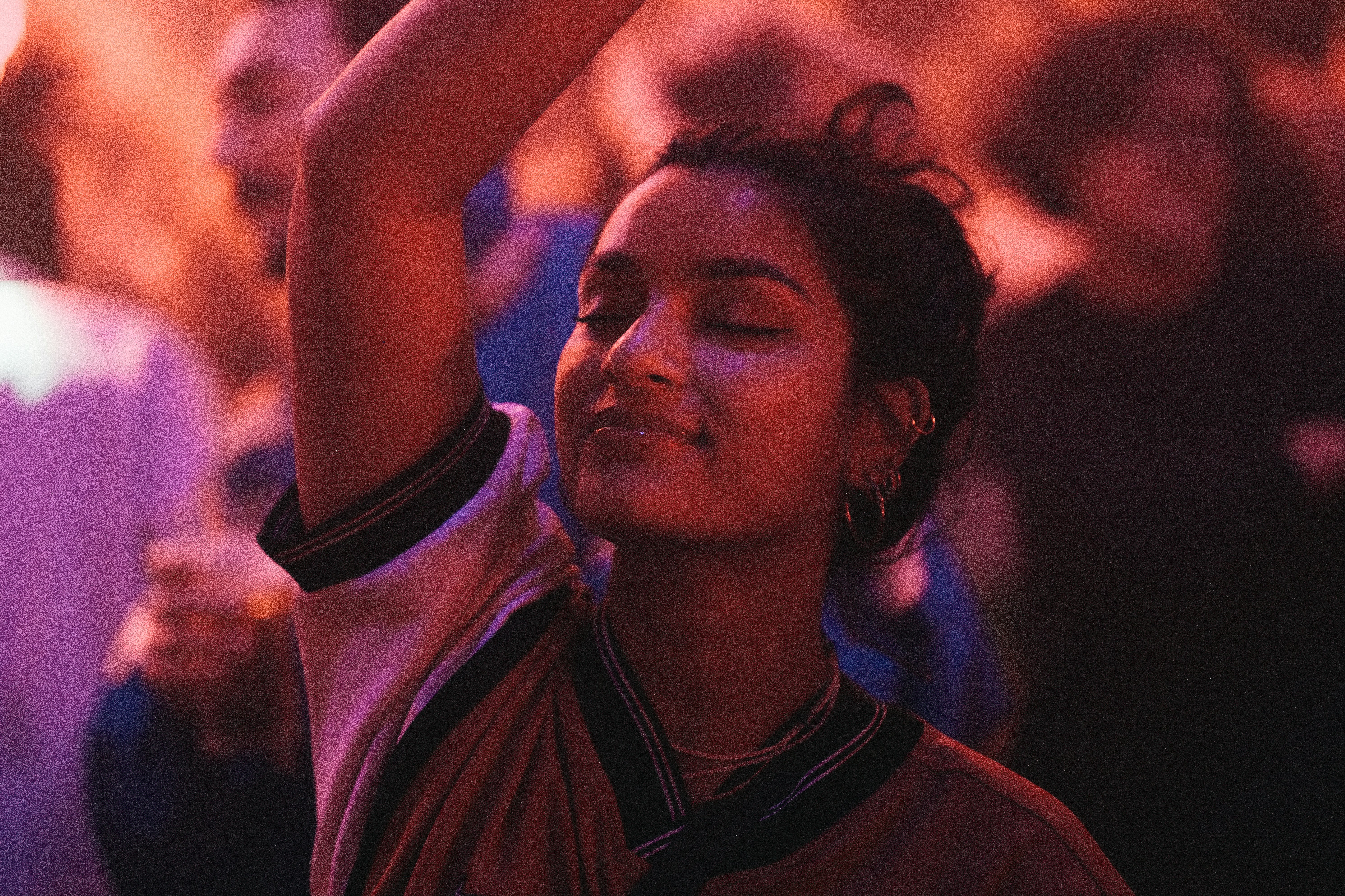 a woman holding a cell phone up in the air