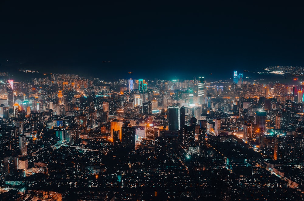 Una vista de una ciudad por la noche desde la cima de una colina