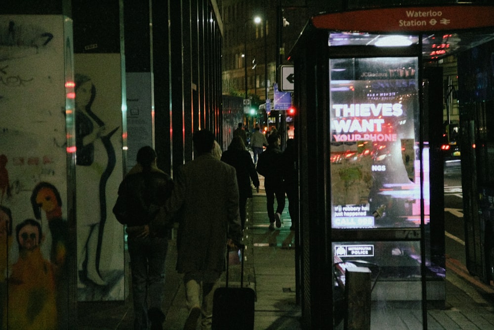 a group of people walking down a sidewalk next to a bus