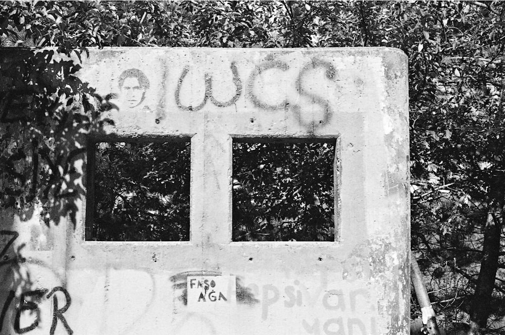 a black and white photo of graffiti on a wall