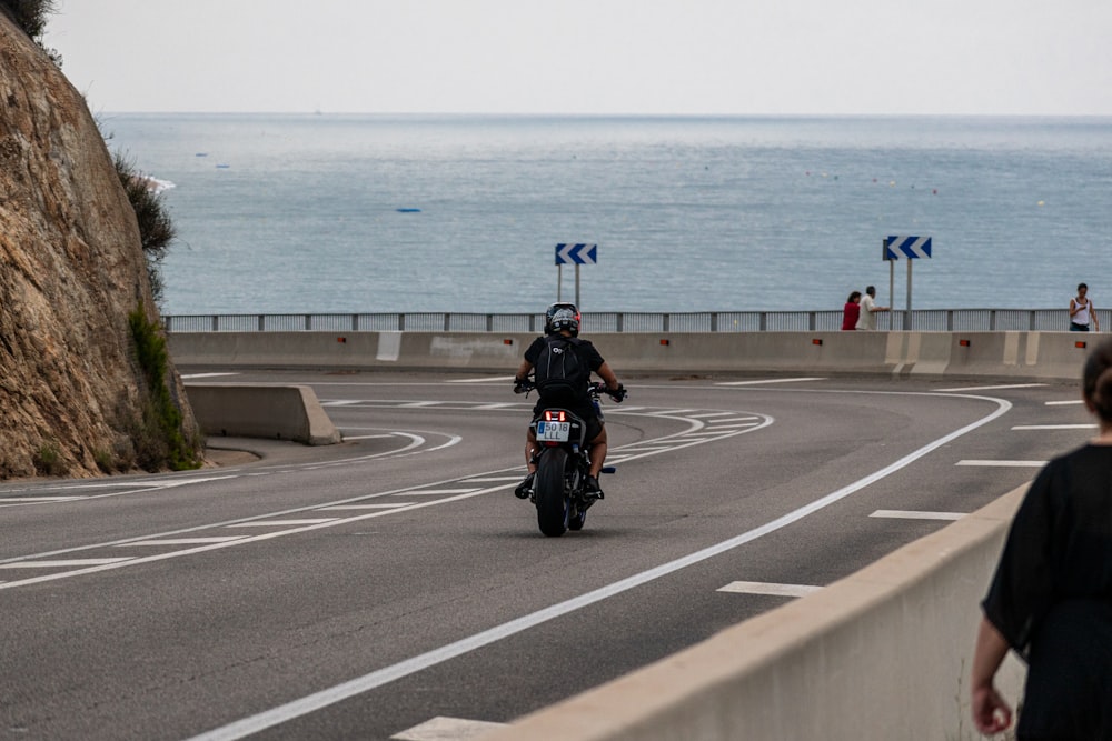 a man riding a motorcycle down a curvy road