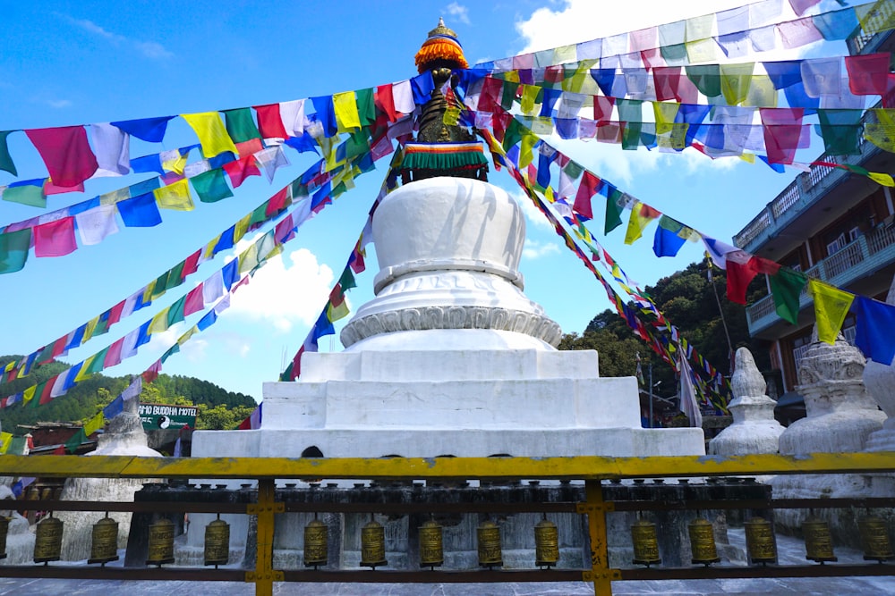 a large white buddha statue sitting under a blue sky