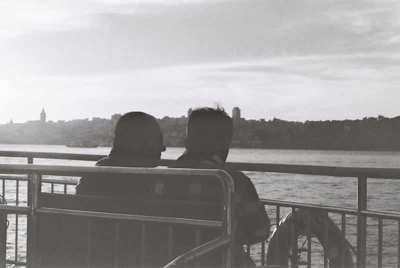 Pareja sentada mirando el mar