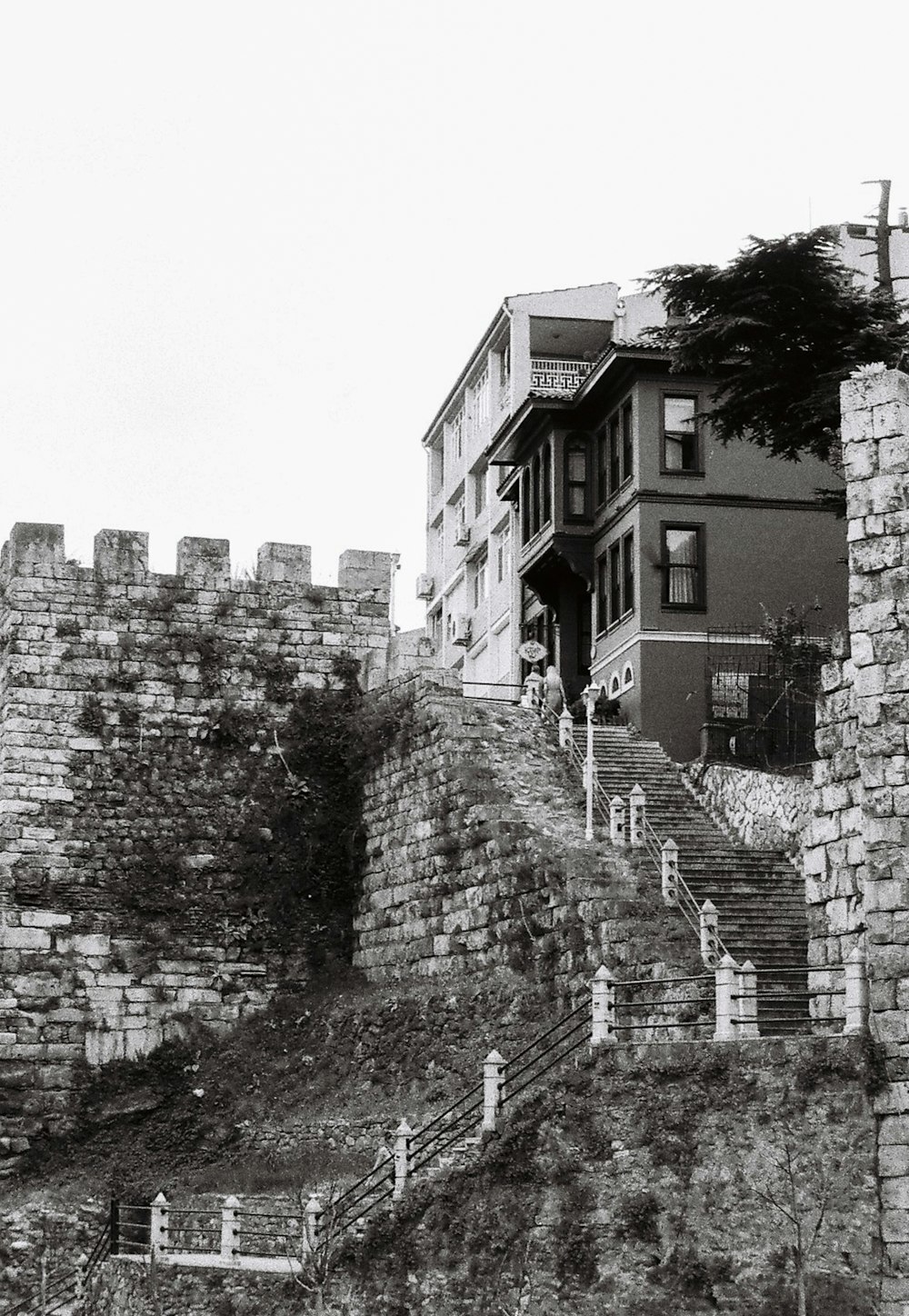 a black and white photo of a building on a hill