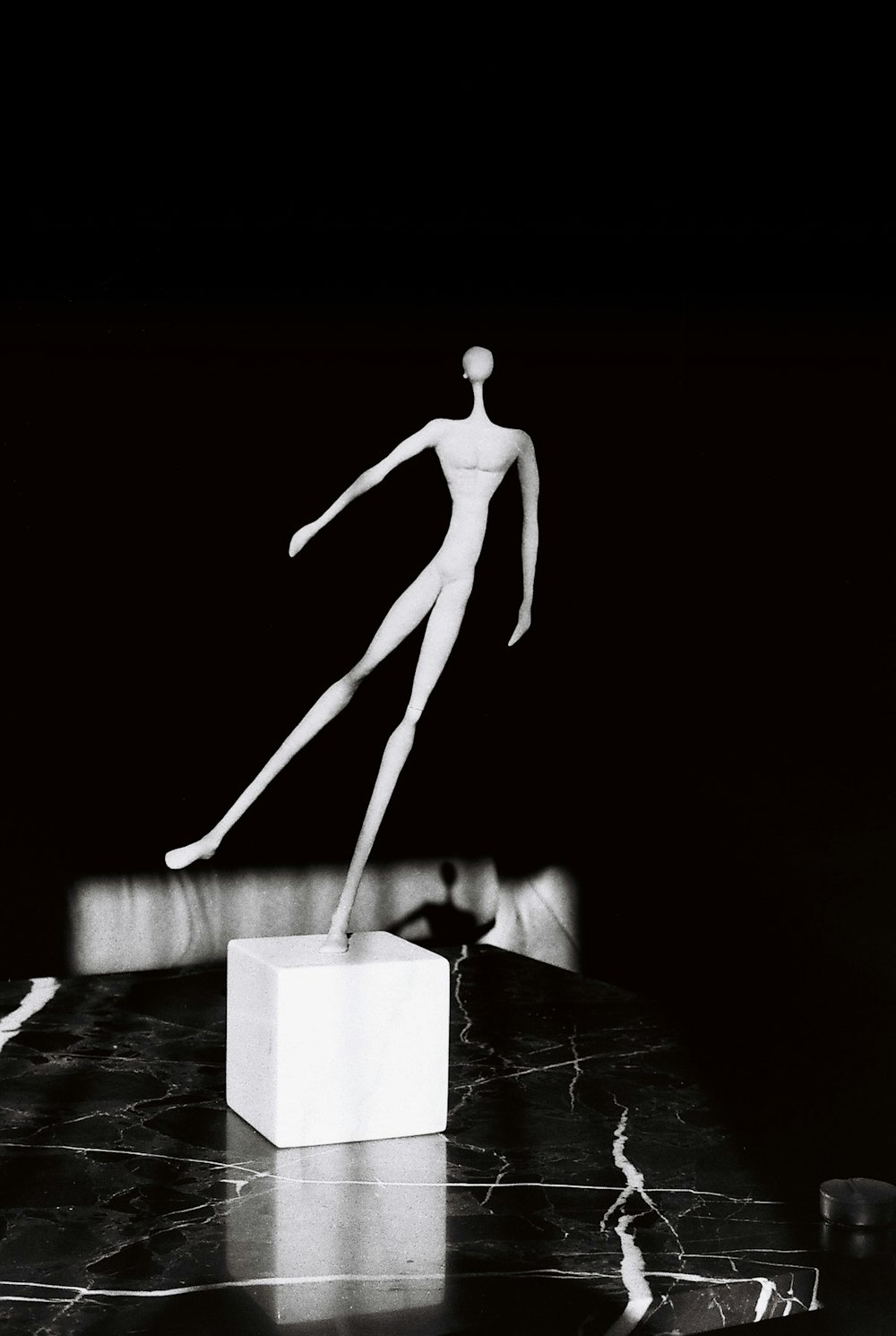 a black and white photo of a mannequin on a table