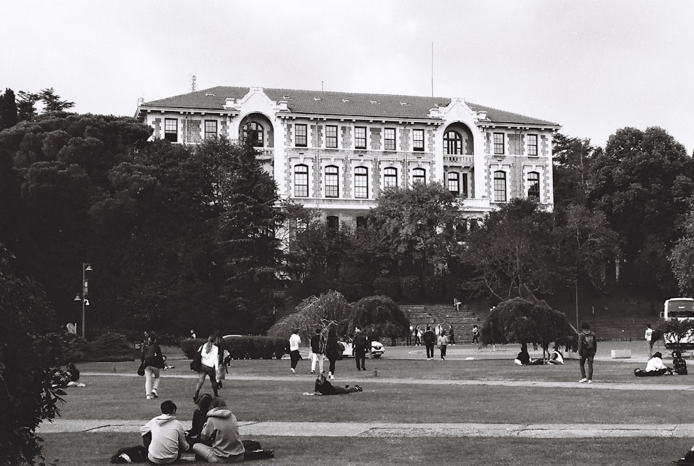 a group of people sitting on top of a lush green field