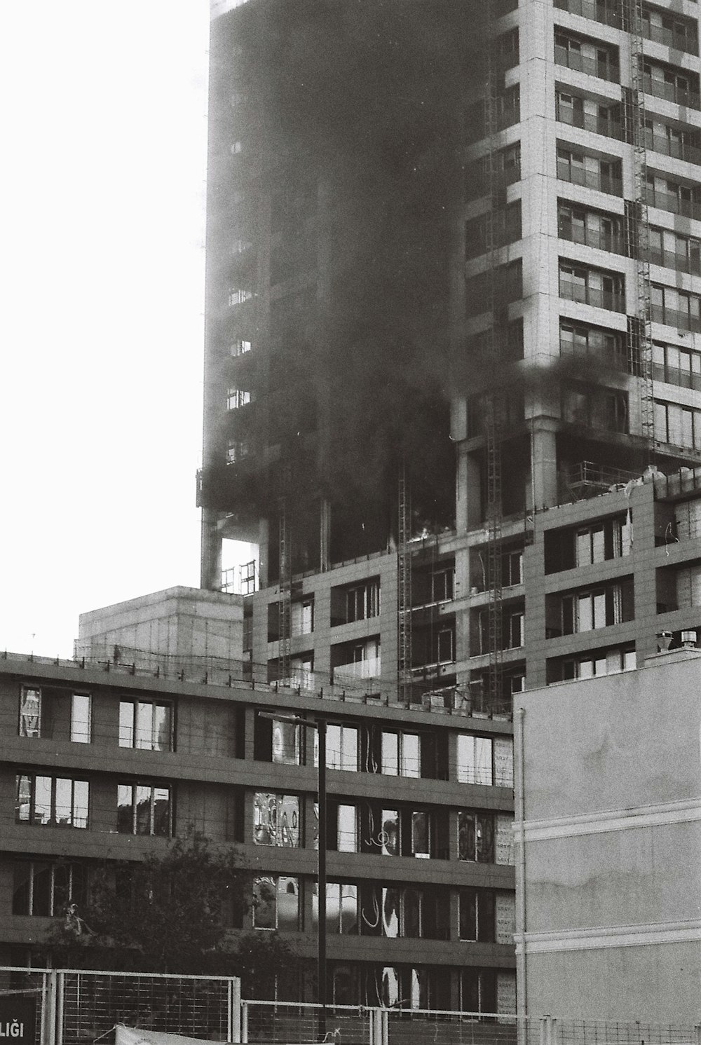 a black and white photo of a building with smoke pouring out of it