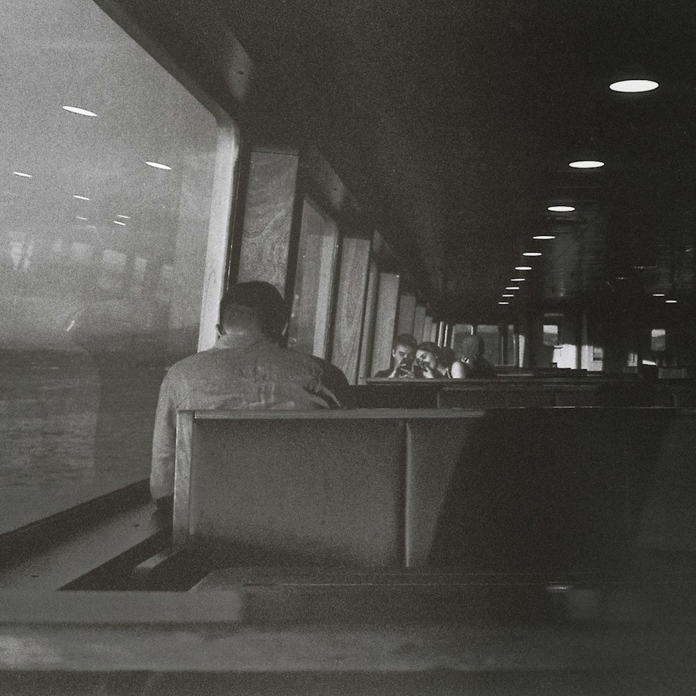 a black and white photo of a man sitting at a counter