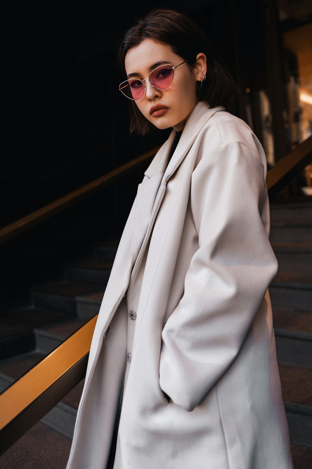 a woman wearing a white coat and sunglasses