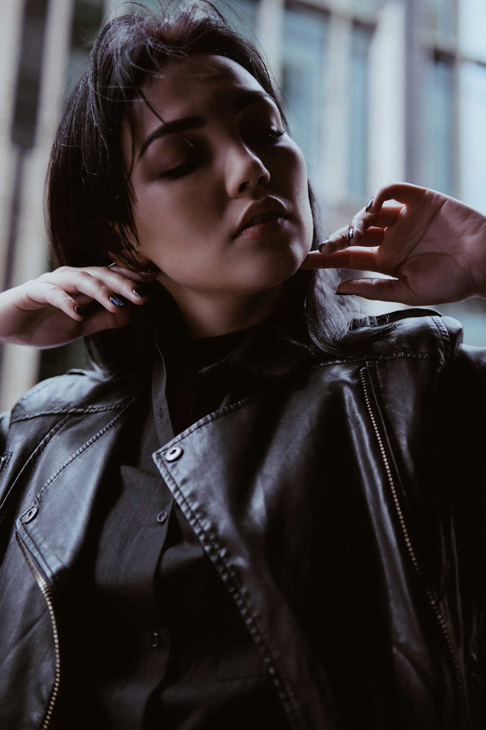 a woman in a black leather jacket is posing for a picture
