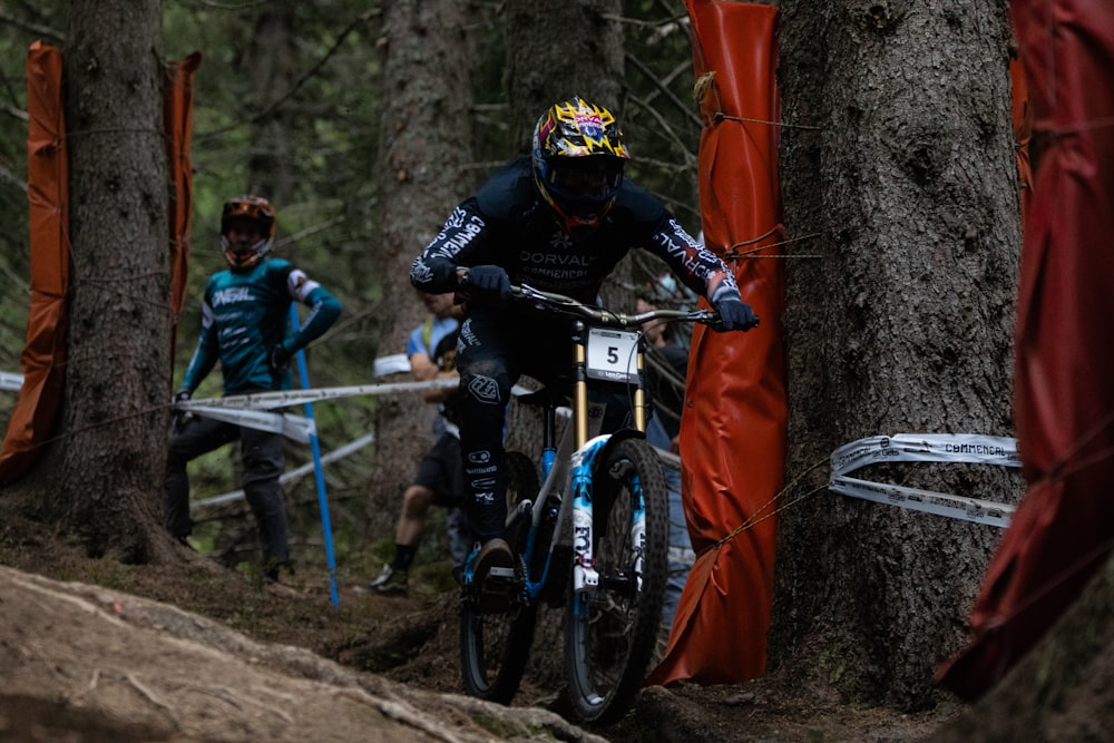 a man riding a bike through a forest