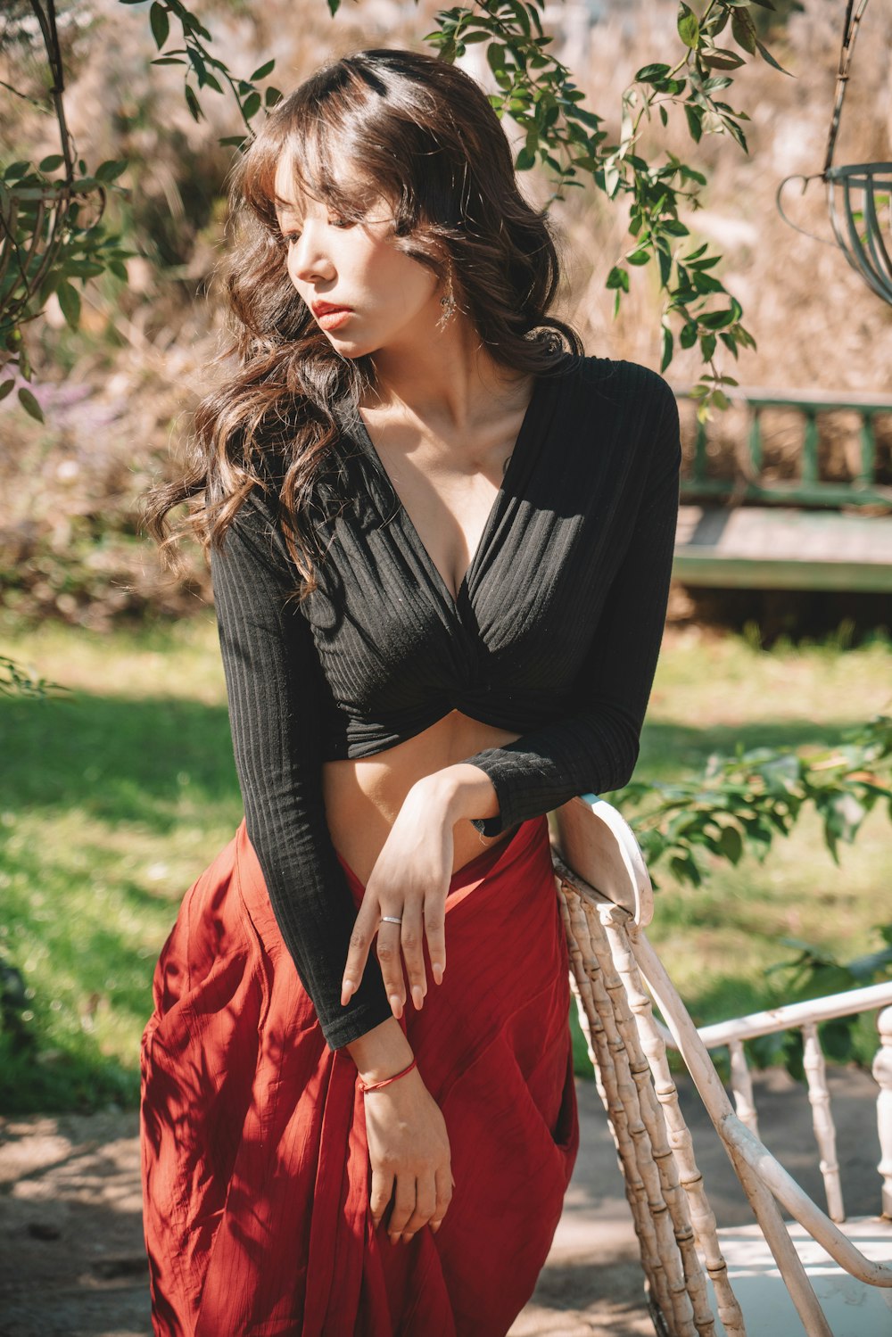 a woman in a black top and a red skirt