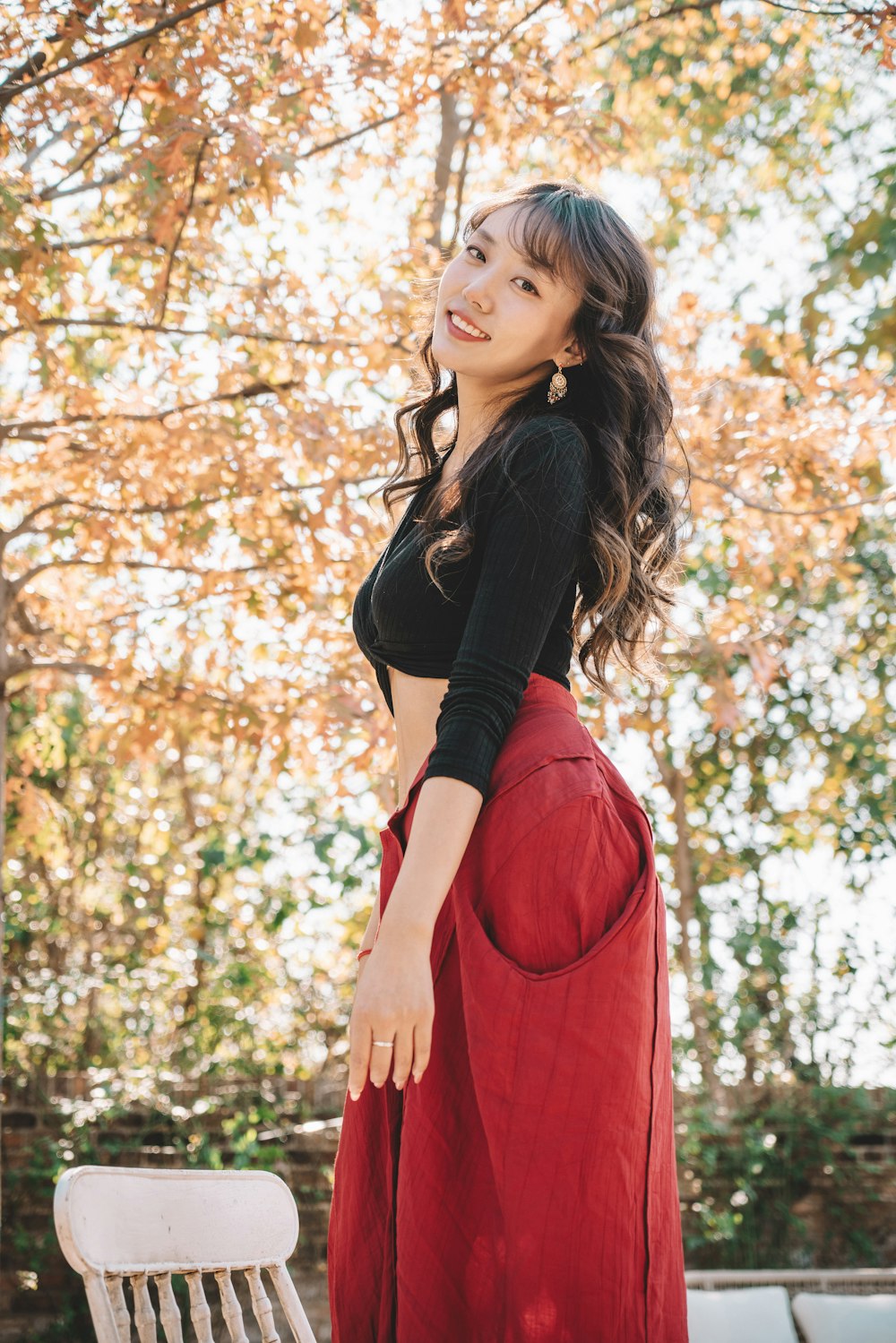 a woman in a black top and red skirt