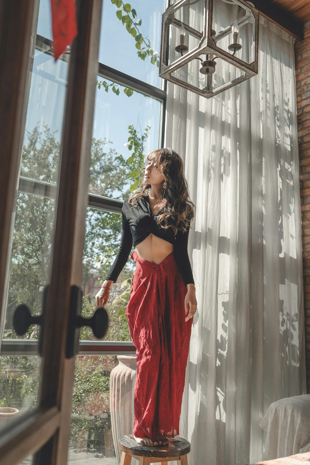 a woman standing on a stool in front of a window