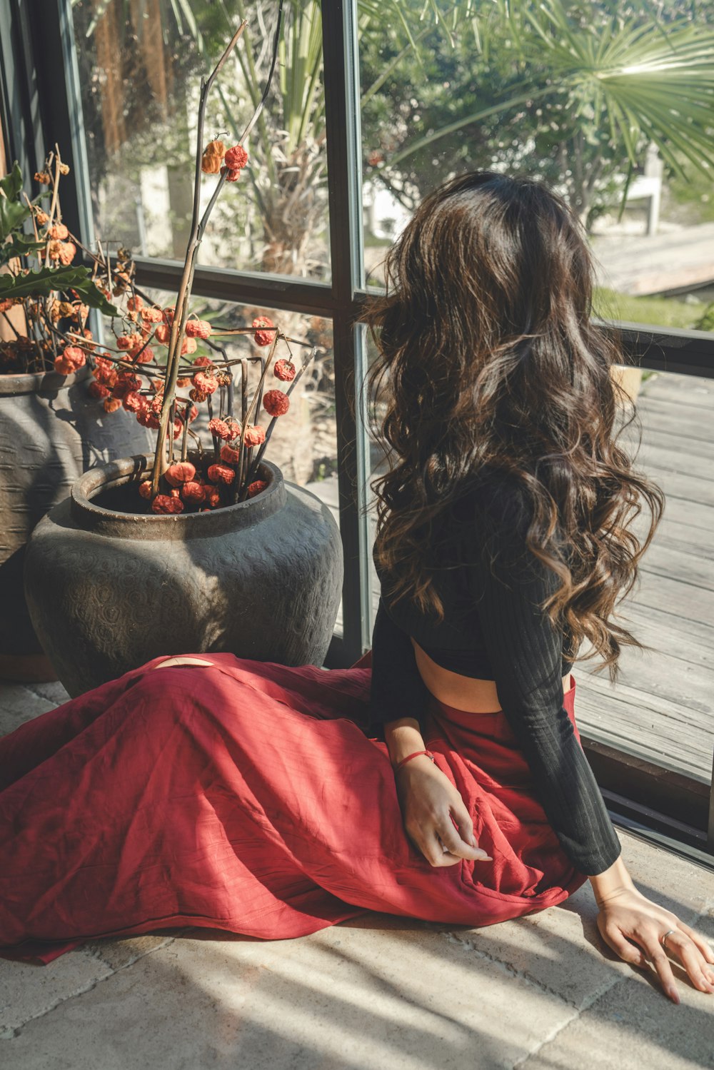 a woman sitting on the floor looking out a window