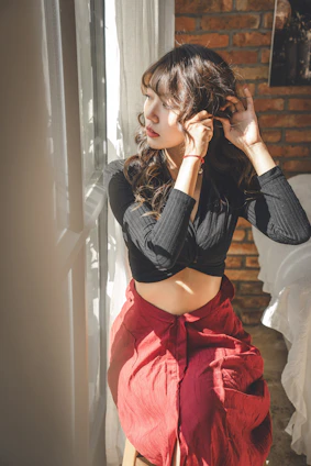 Elegant woman styling her hair in a sunlit room with natural light