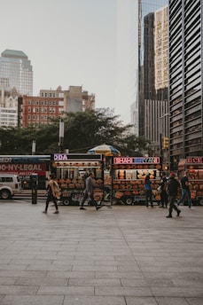 a group of people walking around a food stand
