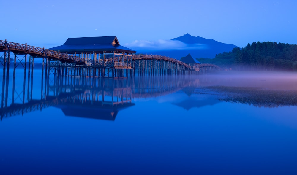 a dock with a house on it in the middle of a lake