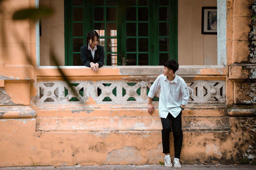 a man standing next to a woman in front of a building