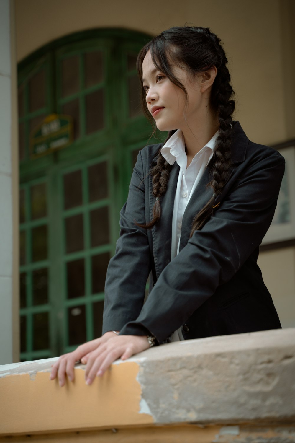 a woman in a business suit leaning on a ledge