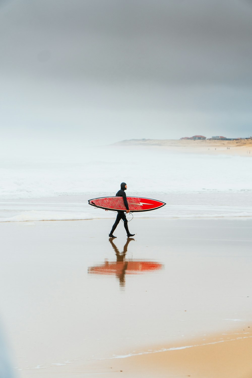 a person walking on a beach with a surfboard