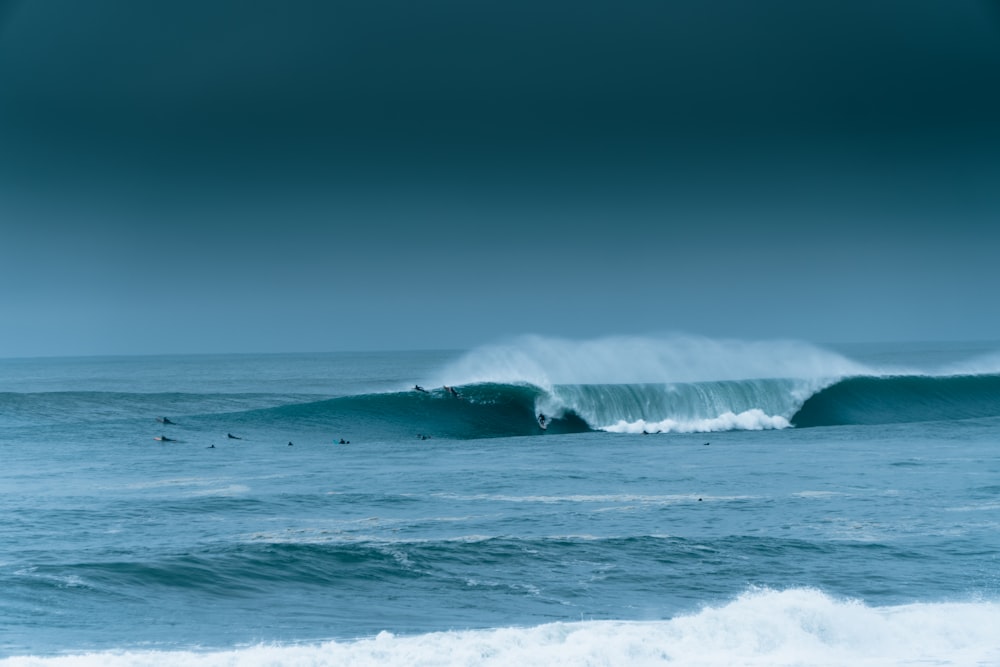 two surfers are riding a large wave in the ocean