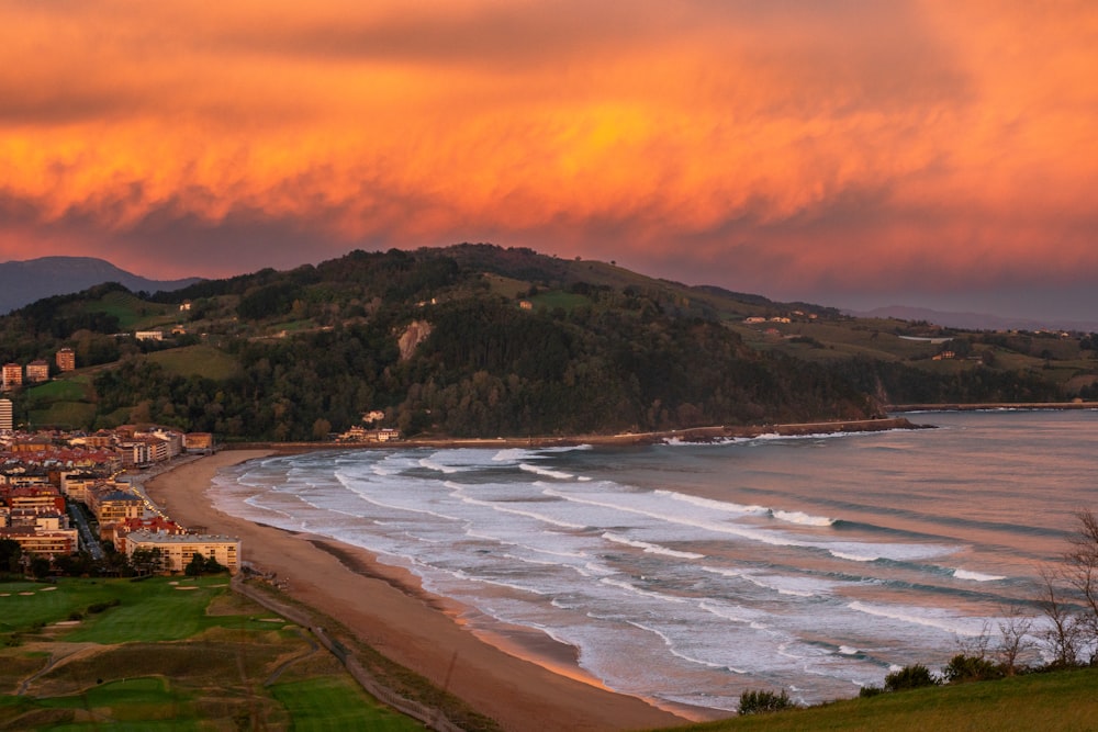 a view of a beach and a city at sunset