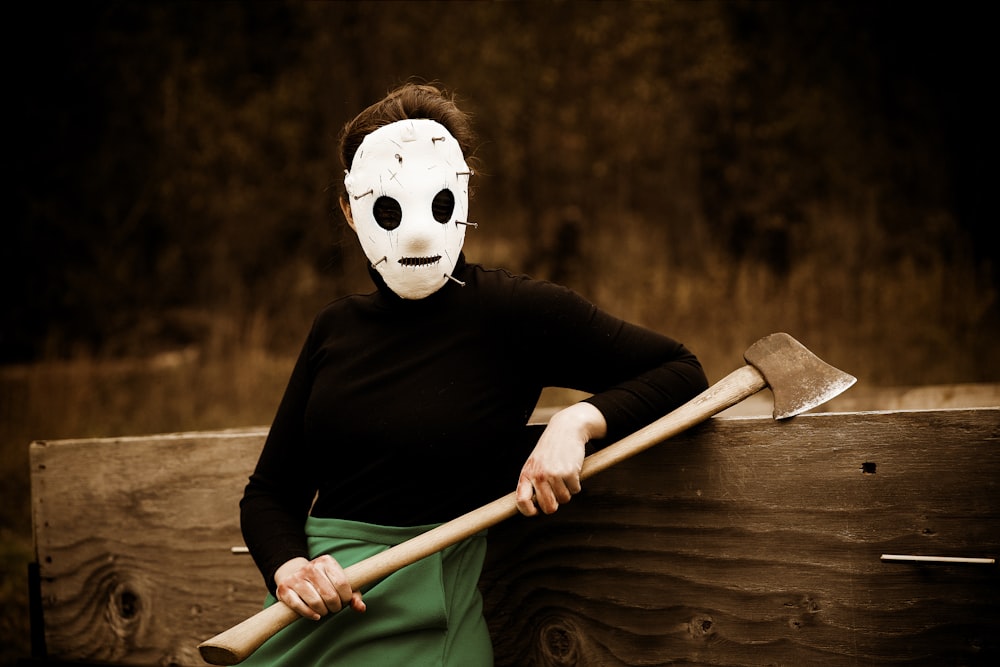 a woman wearing a mask and holding a large axe