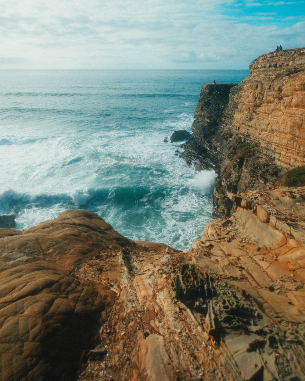 a person standing on a cliff overlooking the ocean