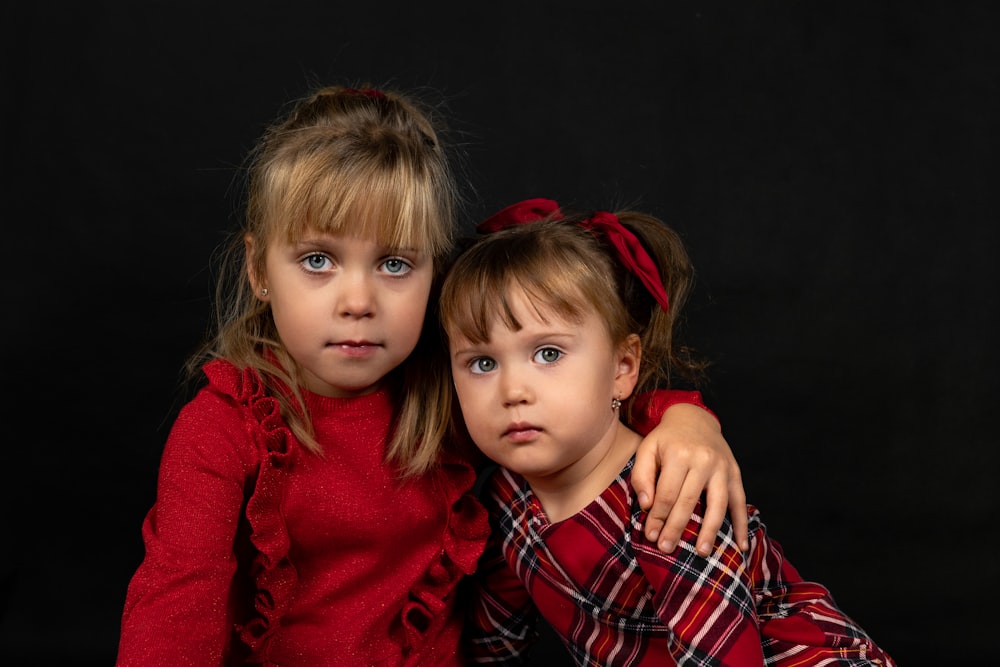 two little girls are posing for a picture