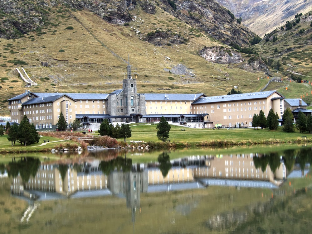 a large building with a clock tower next to a lake