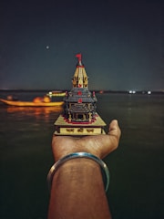 Close-up of a hand-painted temple replica with tiny LED lights highlighting the windows.