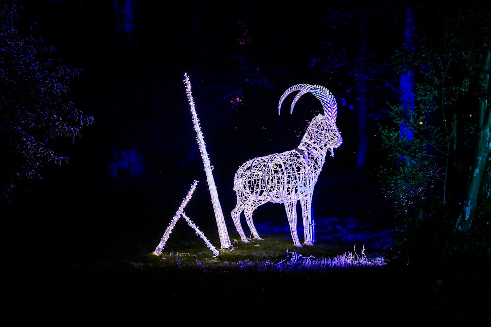a statue of a goat is lit up in the dark